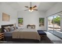 Serene main bedroom featuring soft carpet, vaulted ceilings, ceiling fan, and private outdoor access at 13416 W Ventura St, Surprise, AZ 85379