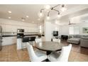 Open floorplan featuring kitchen, dining area, and living room with light fixtures at 17613 N 114Th Ln, Surprise, AZ 85378