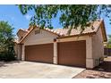 Three-car garage features brown doors and stucco siding, providing ample parking and storage at 18622 N 28Th Way, Phoenix, AZ 85050
