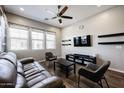 A stylish living room features a brown leather sofa, modern decor, and a ceiling fan at 1871 E Lantana Dr, Chandler, AZ 85286