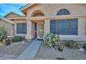 Inviting front entrance of a charming home featuring desert landscaping and an arched window at 18807 N 42Nd Ave, Glendale, AZ 85308