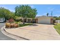 Expansive property showcasing a wide driveway leading to a two-car garage and a well-maintained lawn at 2013 E Solano Dr, Phoenix, AZ 85016