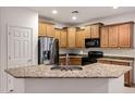 Kitchen featuring stainless steel appliances, granite countertops, wood cabinets, and a kitchen sink at 20160 N Riverbank Rd, Maricopa, AZ 85138