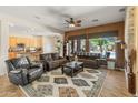 Spacious living room featuring a ceiling fan, plush seating, a decorative rug, and an open floor plan leading to the kitchen at 2222 W Morse Ct, Anthem, AZ 85086