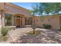 Inviting home entrance with a mature tree, fountain, brick walkway and a custom wood door at 22463 N 54Th St, Phoenix, AZ 85054