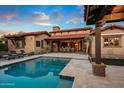 Backyard featuring a sparkling pool, covered patio, and outdoor lounge area with luxury home at 37440 N 104Th Pl, Scottsdale, AZ 85262
