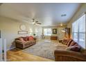 Bright living room featuring wood floors, ceiling fan, and comfortable seating arrangement at 3790 W White Canyon Rd, San Tan Valley, AZ 85144