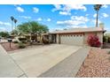 Traditional home with a two-car garage, well-maintained front lawn, desert landscaping, and a serene, cloud-filled sky at 3926 W Christy Dr, Phoenix, AZ 85029
