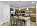 Modern kitchen featuring stainless steel appliances, a large island with barstool seating, and ample cabinetry at 40893 W Bedford Dr, Maricopa, AZ 85138