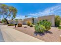 Street view of single-story home featuring a two car garage, mature landscaping, and blue sky background at 4317 E Glenrosa Ave, Phoenix, AZ 85018