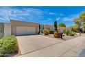Street view of single-story home featuring a two car garage, mature landscaping, and blue sky background at 4317 E Glenrosa Ave, Phoenix, AZ 85018
