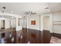 Spacious living room boasts gleaming dark hardwood floors, recessed lighting, and stylish architectural details at 43998 W Palo Abeto Dr, Maricopa, AZ 85138
