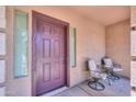 Inviting front porch with seating, neutral stucco, decorative trim and view of windows with venetian blinds at 44158 W Cypress Ln, Maricopa, AZ 85138