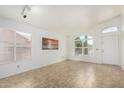 Bright living room featuring neutral tile flooring and plenty of natural light from large windows at 626 W Catclaw St, Gilbert, AZ 85233