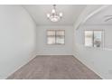 Well-lit living area featuring plush carpeting, and a chandelier at 708 E Mule Train Trl, San Tan Valley, AZ 85143