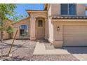 Welcoming front entrance with decorative pillars, desert landscaping, and a two-car garage on the side at 7239 E Madero Ave, Mesa, AZ 85209
