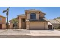 Inviting home exterior featuring a two-car garage, desert landscaping, and a covered entryway at 7239 E Madero Ave, Mesa, AZ 85209