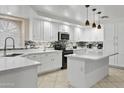 A bright kitchen features white cabinets, granite countertops, and stainless steel appliances at 7340 W Bronco Trl, Peoria, AZ 85383