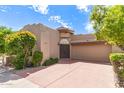 Charming home featuring well-maintained desert landscaping, a two-car garage, and a welcoming courtyard entrance at 7955 E Chaparral Rd # 141, Scottsdale, AZ 85250