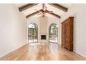 Inviting living room with wood floors, vaulted ceilings, fireplace, arched windows, and exposed beams at 7955 E Chaparral Rd # 141, Scottsdale, AZ 85250
