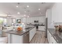 Bright kitchen boasts white cabinets, stainless steel appliances, granite counters and center island with seating at 8010 W Atlantis Way, Phoenix, AZ 85043