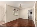 Dining area with hardwood floors, chandelier, and doorway to a kitchen with checkerboard tiles at 8121 N 8Th Ave, Phoenix, AZ 85021