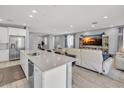 Bright, open-concept living space featuring light wood flooring, a sleek kitchen island and comfortable seating at 9444 W Roma Ave, Phoenix, AZ 85037