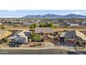 Wide aerial view of home showing its location within a neighborhood and views of distant mountains at 9719 W Heber Rd, Tolleson, AZ 85353