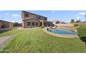 Expansive backyard with a covered patio, swimming pool, and well-maintained lawn at 9719 W Heber Rd, Tolleson, AZ 85353
