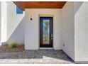 Elegant home entrance featuring a sleek glass door and stylish stone walkway and landscaped yard at 100 W Northern Ave # 12, Phoenix, AZ 85021