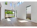 Sunlit living space with high ceilings, large windows, and a modern chandelier and backyard access at 100 W Northern Ave # 12, Phoenix, AZ 85021