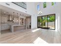 Bright, open-concept living area featuring a modern kitchen, sleek light fixtures, and backyard access at 100 W Northern Ave # 12, Phoenix, AZ 85021