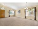 Spacious living room with neutral carpet, high ceilings, and views of the front yard at 1049 N Monterey St, Gilbert, AZ 85233