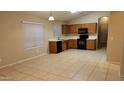 Spacious kitchen featuring tiled floors, modern appliances, ample countertop space, and wood cabinets at 10645 W Piccadilly Rd, Avondale, AZ 85392
