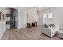 Bright living room with hardwood floors, white walls, large windows, and a cozy grey sofa at 11611 N 149Th Ln, Surprise, AZ 85379