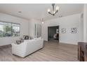 Light-filled living room with wood floors, neutral walls, and an open doorway to another room at 11611 N 149Th Ln, Surprise, AZ 85379