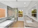 Bright bathroom with dual sinks, a glass-enclosed shower, and a soaking tub at 11889 N 113Th Pl, Scottsdale, AZ 85259