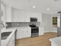 Bright kitchen featuring white cabinets, stainless steel appliances, and wood flooring at 11889 N 113Th Pl, Scottsdale, AZ 85259