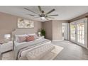 Spacious bedroom with a king bed, a ceiling fan, and access to the outdoor patio through french doors at 11889 N 113Th Pl, Scottsdale, AZ 85259