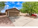 View of the home's garage and driveway set against a blue sky at 12230 W Larkspur Rd, El Mirage, AZ 85335