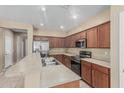 Well-lit kitchen featuring stainless steel appliances, laminate countertops, and wood cabinets at 15420 W Canterbury Dr, Surprise, AZ 85379