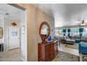 Open-concept entryway featuring a wood dresser with mirror, flowing into the living room at 15976 W La Paloma Dr, Surprise, AZ 85374
