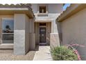 Inviting front entrance with security door, decorative niche, and desert plants at 15976 W La Paloma Dr, Surprise, AZ 85374
