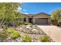 Attractive single-story home with desert landscaping, brick accents, a tile roof, and a paver driveway at 16389 W Fawn Dr, Goodyear, AZ 85338