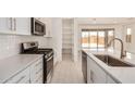 Bright kitchen features stainless appliances, white cabinetry, subway tile backsplash and outdoor views at 18210 W Hess St, Goodyear, AZ 85338