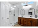 Bright bathroom features a glass-enclosed shower, double sink vanity with wood cabinetry, and stylish fixtures for a spa-like experience at 19172 E Kingbird Dr, Queen Creek, AZ 85142