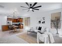 Open-concept living space features a cozy seating area, dining table, and views of the modern kitchen in a comfortable design at 19172 E Kingbird Dr, Queen Creek, AZ 85142