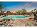 Backyard pool with diving board surrounded by desert landscaping and wood fencing at 2024 N 200Th Ave, Buckeye, AZ 85396
