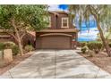 A two-story brown home with a two car garage and a well-manicured front yard at 20261 W Desert Bloom St, Buckeye, AZ 85326