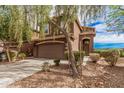 Charming brown two-story house with a covered entry and lush landscaping at 20261 W Desert Bloom St, Buckeye, AZ 85326